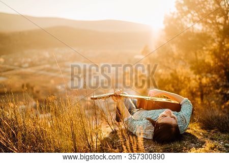 Young Guitarist Playing Acoustic Guitar And Enoying The Sunset.learning To Play An Instrument.singer