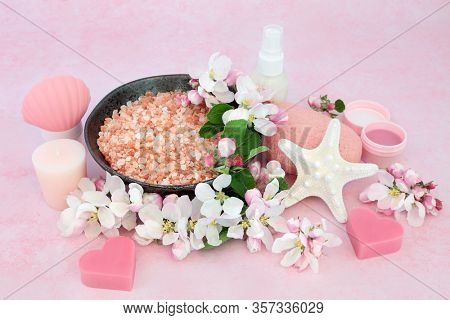Vegan skincare beauty treatment with spa, ex foliation & cleansing products with apple blossom flowers on pink background. Health care anti ageing concept.