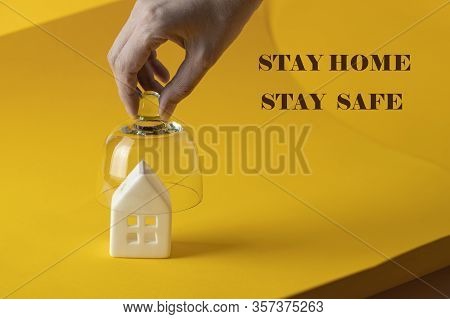 Hand Put Crystal Top For Protect The House On Yellow Background. Lockdown During A Viral Pandemic Co