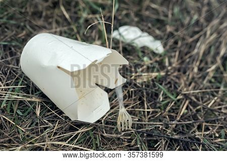 Plastic Disposable Cup On Grass In The Park. Ecological Disaster And Environmental Pollution. Garbag