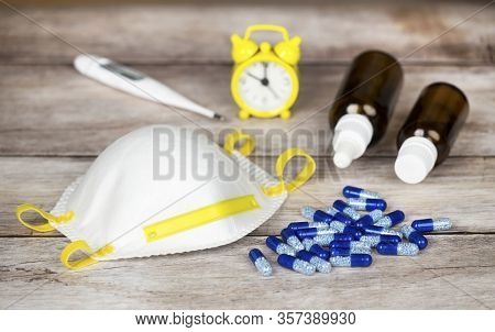 Coronavirus Home Treatment, Medicines Concept. Prevention Mask, Pill Capsules, Thermometer, Nose-dop