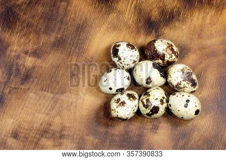 Raw Organic Qual Eggs On A Wooden Table.
