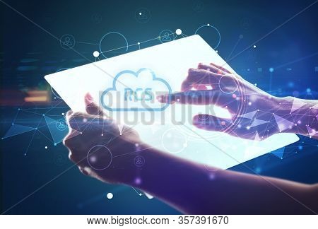 Hand holdig futuristic tablet with RCS inscription, modern technology concept
