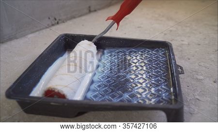 Painting Out A Bare Wall With A Paint Roller With Gray Paint. Hand Painting Using Paint Roller. Pain