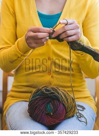 Female Hands Close-up. Young Woman Is Knitting. Knitting Needles And Threads. Multi-colored Yarn. Ha