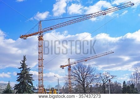 Construction Cranes On A Construction Site, Against The Sky