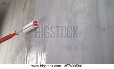 Painting Out A Bare Wall With A Paint Roller With Gray Paint. Hand Painting Using Paint Roller. Pain