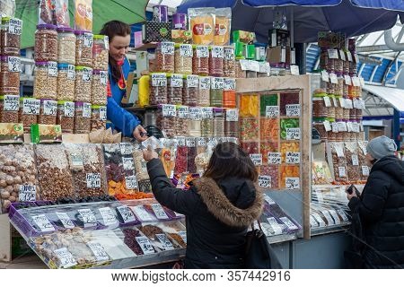 Minsk, Belarus - March 20, 2020: Sale Of Different Sweets, Nuts And Dry Fruits On Market. A Woman Bu