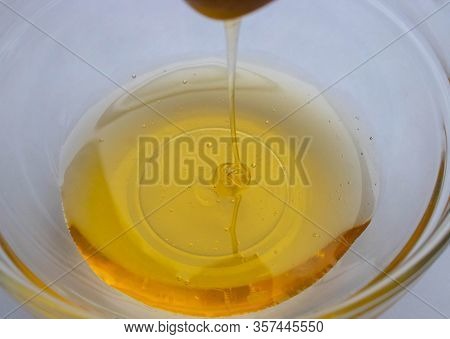 Honey Dipper On The Bee Honeycomb Background. Honey Tidbit In Glass Jar And Honeycombs Wax