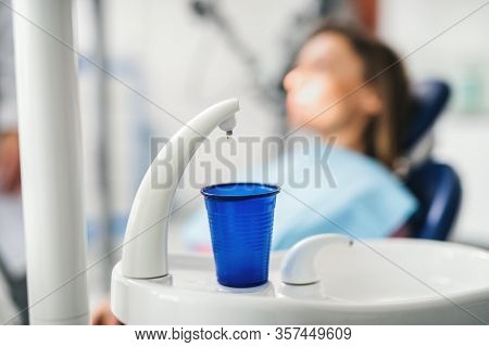 Close-up Of Plastic Cup In Dentist Surgery, Annual Check-up Concept.