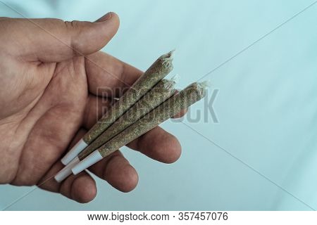 Pre-rolled Marijuana Joints Or Cannabis Ready To Smoke In Male Hand. Amsterdam Famous Legal Drug.