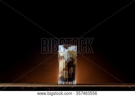 Iced Latte With Dark Background On A Wooden Table. Milky Iced Coffee