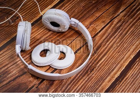 Need A Replacement Embouchures On Old White Earbud. Repair Accessories.wooden Background