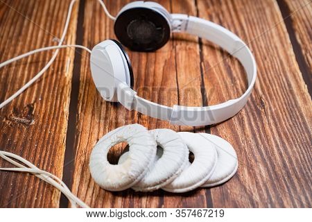 Need A Replacement Embouchures On Old White Earbud. Repair Accessories.wooden Background