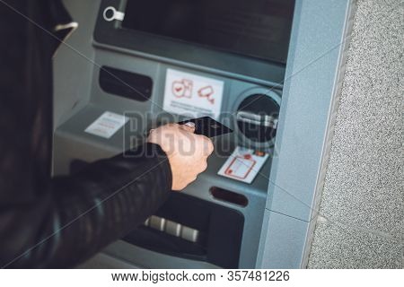 Atm Cash Withdrawal. Woman Using Atm Machine To Withdraw Her Money. Close-up Of Female Hand With Cre