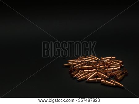 Unloaded Hunting Bullets Laying In A Pile On A Black Background With Room For Text