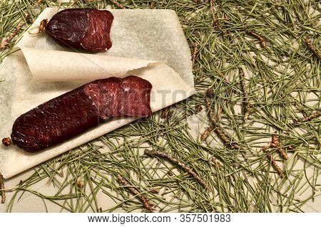 Dried Sausage Made Of Roe Deer Meat. Cut With Slices On Parchment, A Large Fragment. Flooring Made O