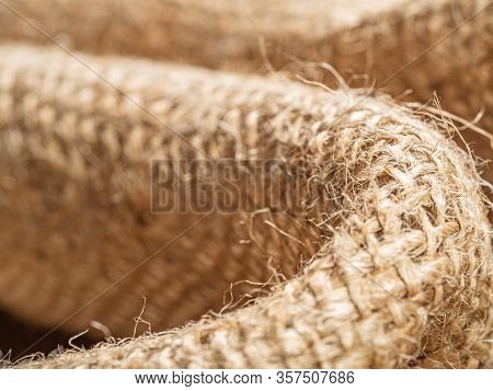 Close Up View On Burlap Textile. Crumpled Sackcloth, An Abstract Background. Texture Of Brown Baline