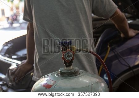 Close Up Tank Valve Of Freon Bottle With Auto Mechanic Worker With Tools For Refuel Fixing Evaporato