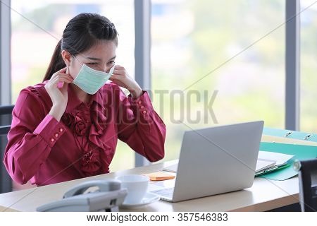 Female Employee Wearing Put On Surgical Hygienic Mask On Her Face For Protect Herself From Dangerous
