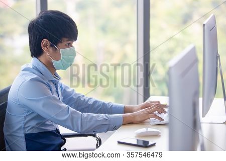 Male Employee Working And Wearing  Surgical Hygienic Mask On His Face For Protect Herself From Dange
