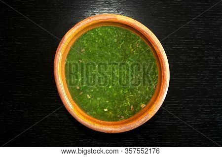Famous Traditional Arabic Cuisine. Molokhia Soup In Brown Bowl On Dark Wooden Background. Flat Lay, 