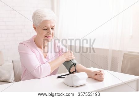 Everyday Health Check-up. Senior Lady With Hypertension Measuring Blood Pressure Herself At Home, Em