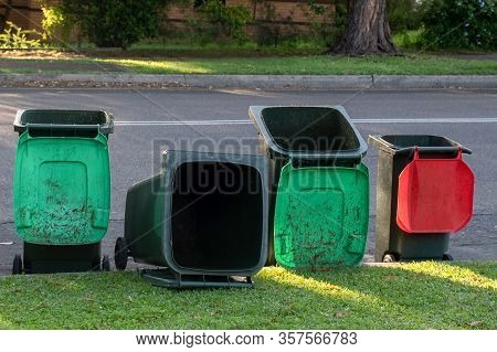 Australian Garbage Wheelie Bins Staying And Laying On A Kurb Side After Council Colleciton. Green Li