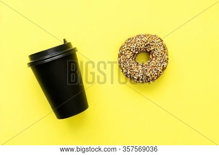 Coffee And Donut For Breakfast On Yellow Background. Black Paper Glass And Chocolate Donut.