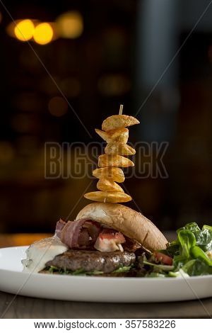 Burger Of Beef Meat With Melted Chedar Cheese, Bacon,tomato, Rocket Salad With Spicy Fries On The Ta