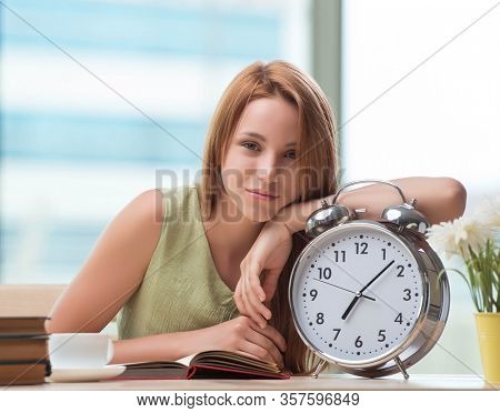 Student with gian alarm clock preparing for exams