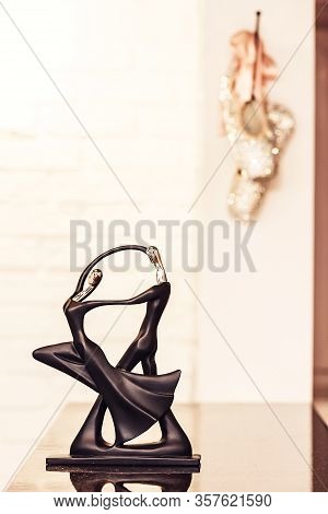 Figurine Of Dancers On The Table And Ballet Shoes On The Wall At The Dance School