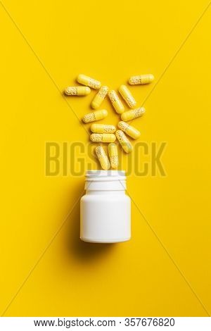 Vitamin capsules. Vitamin C pills on yellow background. Top view.