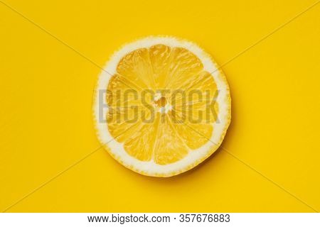 Slice of yellow lemon on yellow background. Top view.