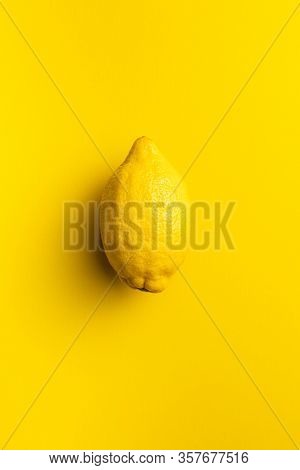 Yellow lemon fruit on yellow background. Top view.