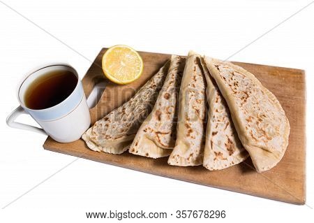 Indian Chiapati With Lemon And Black Tea With No Yeast On A Kitchen Board On A White Background