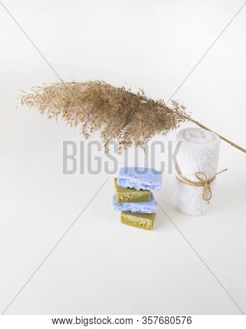 Homemade Lavender And Olive Soap Bars, Whitel Towel And A Dry Reed On White Background. Set Of Plast