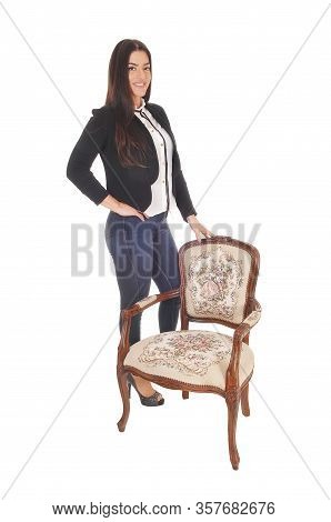 A Gorgeous Caucasian Woman In Jeand And A Black Jacket Standing
With An Old Armchair, Isolated For W