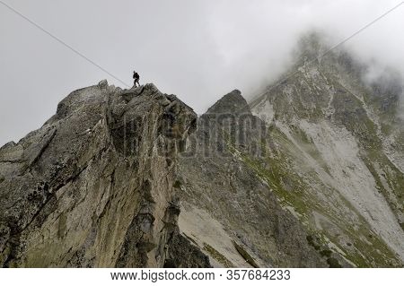 A Small Man On The Background Of Huge Mountains. Solisko. High Tatras. Slovakia. Mountain Ridge View