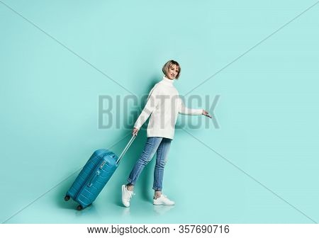 Attractive Blonde Girl In White Sweater, Jeans And Sneaker Smiling Posing With Suitcase Luggage Stan