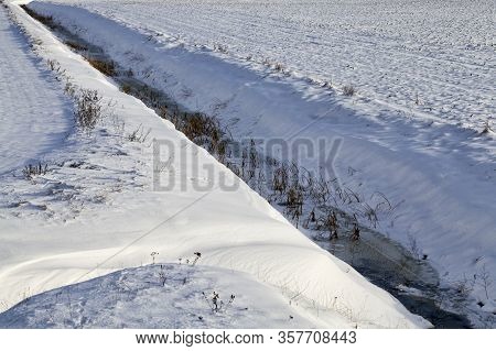 Thin Ordinary Stream Covered With Snow And A Thin Layer Of Ice During The First Frost, Top View From