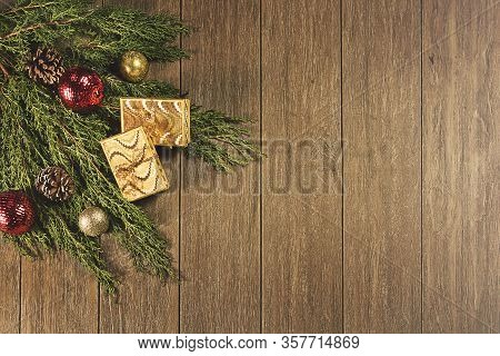 Christmas decoration wreath on the dark vintage wooden background. Gift boxes, wreath and golden sta