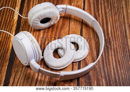 Need A Replacement Embouchures On Old White Earbud. Repair Accessories.wooden Background