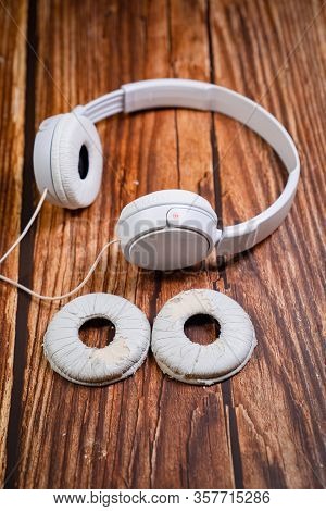 Need A Replacement Embouchures On Old White Earbud. Repair Accessories.wooden Background