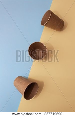 Three Craft Paper Cups For Coffee Or Any Drinks On A Blue And Yellow Paper Background. Concept Of Zi