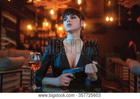 Portrait Of A Beautiful Sexy Woman With A Gun In Her Hands.