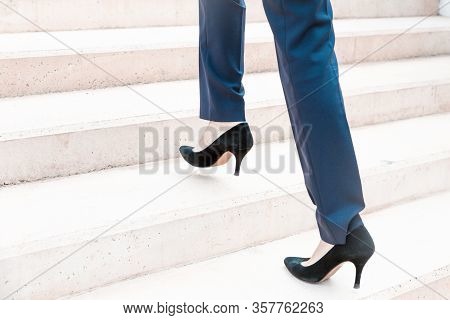 Businesswoman Walking Upstairs. Legs And Feet Of Business Woman Wearing Formal Trousers And Shoes. W