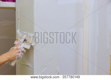 Hand Holding Plastering Tool House Improvements. Putting Plaster On The Wall With Spatula