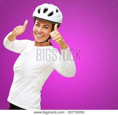 Femme portant casque montrant le pouce en haut isolé sur fond rose