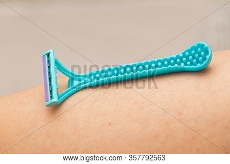 Close Up Picture Of Woman Holding Razor, Shaving Her Hairy Leg With Folliculitis